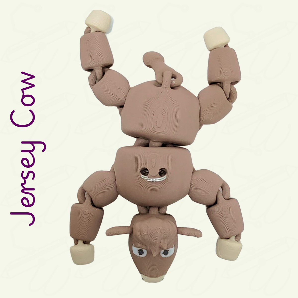 Jersey cow keychain viewed from the top on a beige background. The keychain is milk chocolate brown with beige feet, inner ears, and nose.
